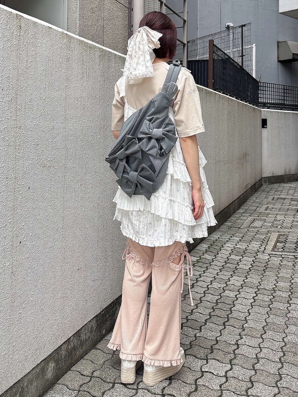 ピンク系のワンピース、ピンク系のスウェットパンツ、ホワイト系のサンダルを着用したレディースの夏コーディネートの2枚目の写真