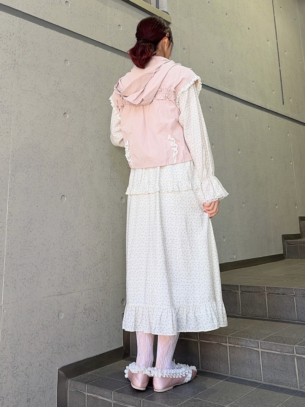 ホワイト系のワンピース、ピンク系のバレエシューズ、ピンク系のベストを着用したレディースの冬コーディネートの2枚目の写真