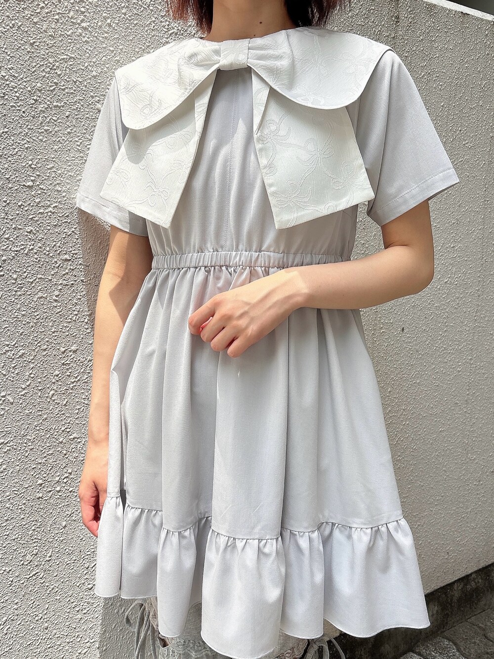 ブルー系のワンピース、グレー系のスウェットパンツ、ホワイト系のスニーカーを着用したレディースの春コーディネートの5枚目の写真