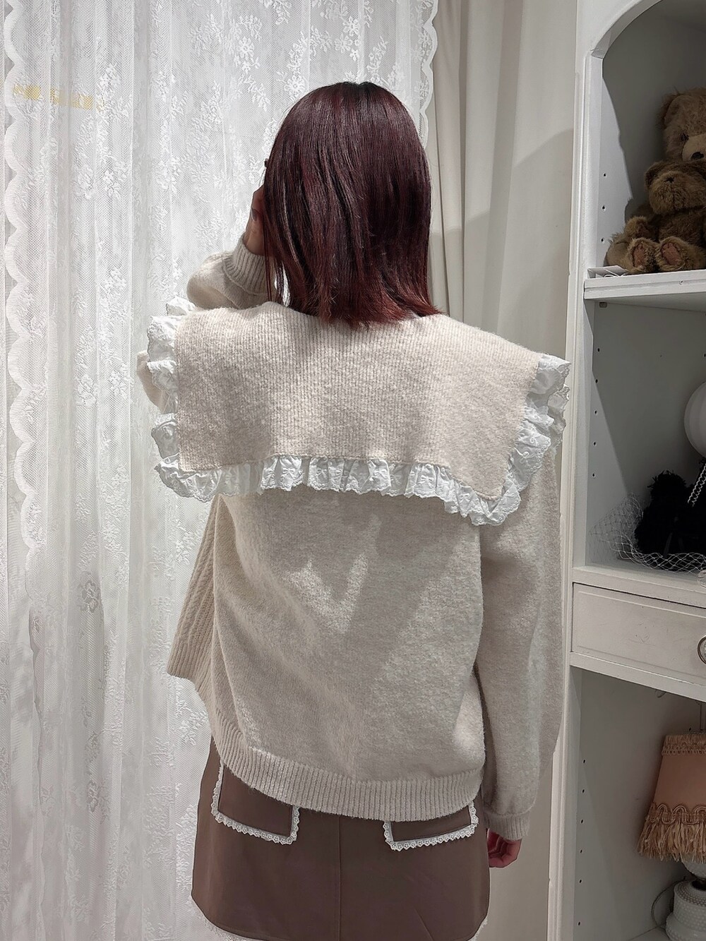 ブラウン系のスカート、ブラック系のブーツ、ホワイト系のカーディガン/ボレロを着用したレディースの秋コーディネートの4枚目の写真