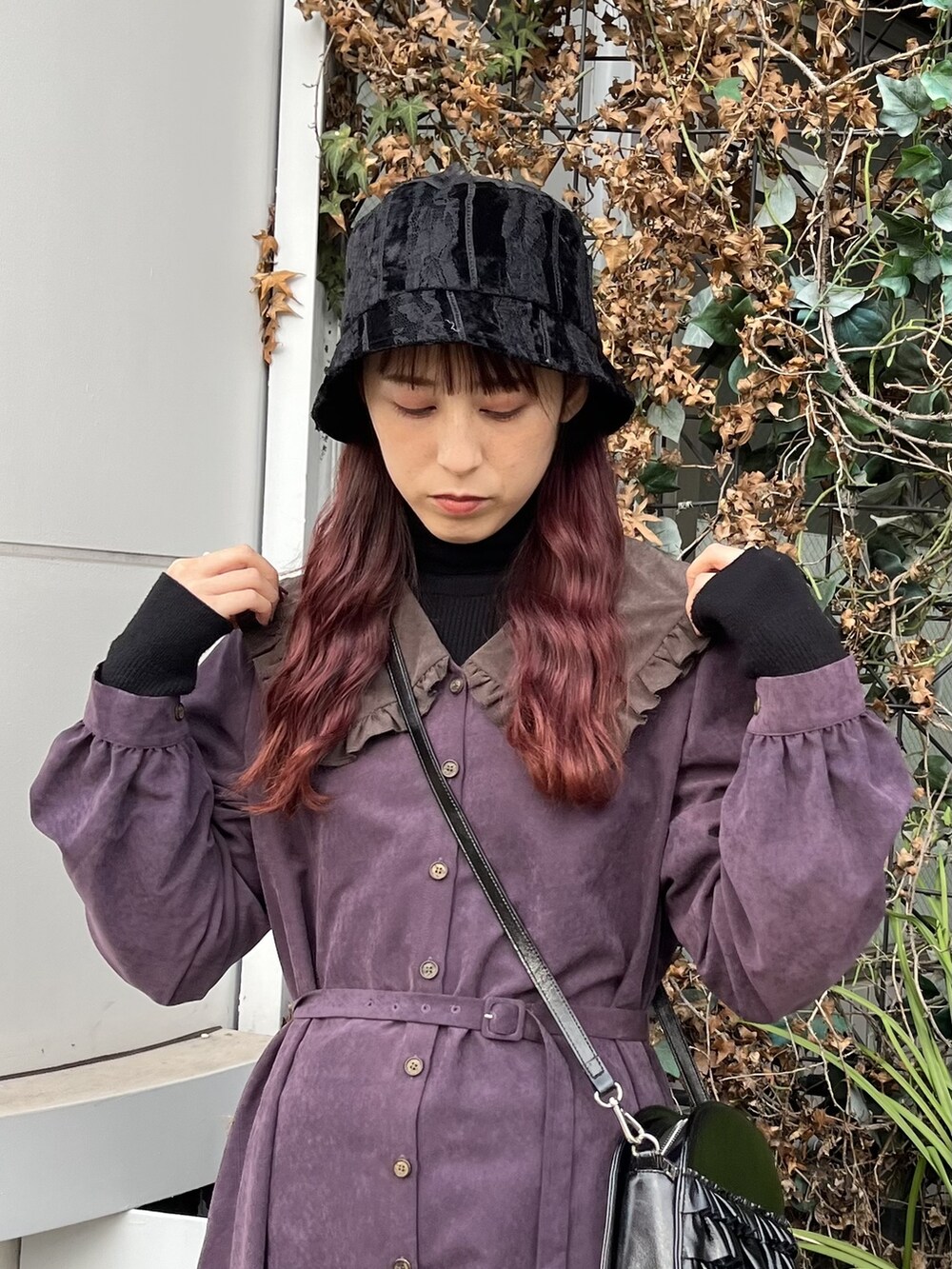 ブラック系のショルダーバッグ、ブラック系のブーツ、ブラック系のニット/セーターを着用したレディースの冬コーディネートの2枚目の写真