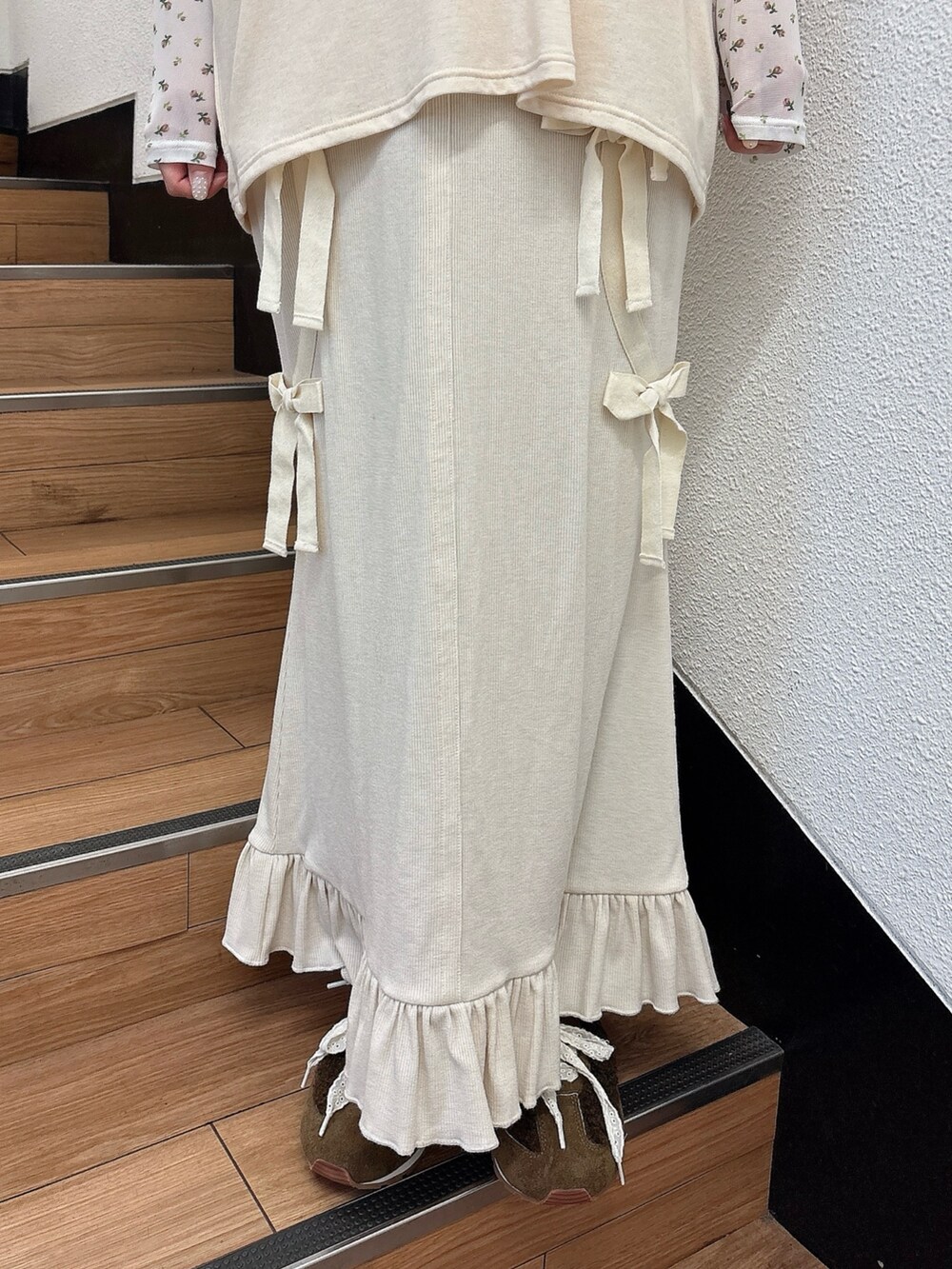 ホワイト系のTシャツ/カットソー、ホワイト系のスカート、ブラウン系のスニーカーを着用したレディースの夏コーディネートの6枚目の写真