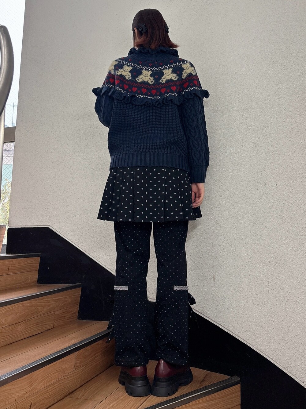 ブルー系のニット/セーター、ブラック系のスラックス、ブラック系のスカートを着用したレディースの秋コーディネートの2枚目の写真