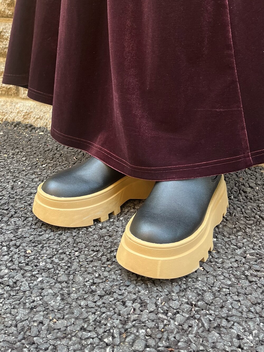 ホワイト系のニット/セーター、レッド系のスカート、ブラック系のブーツを着用したレディースの秋コーディネートの3枚目の写真