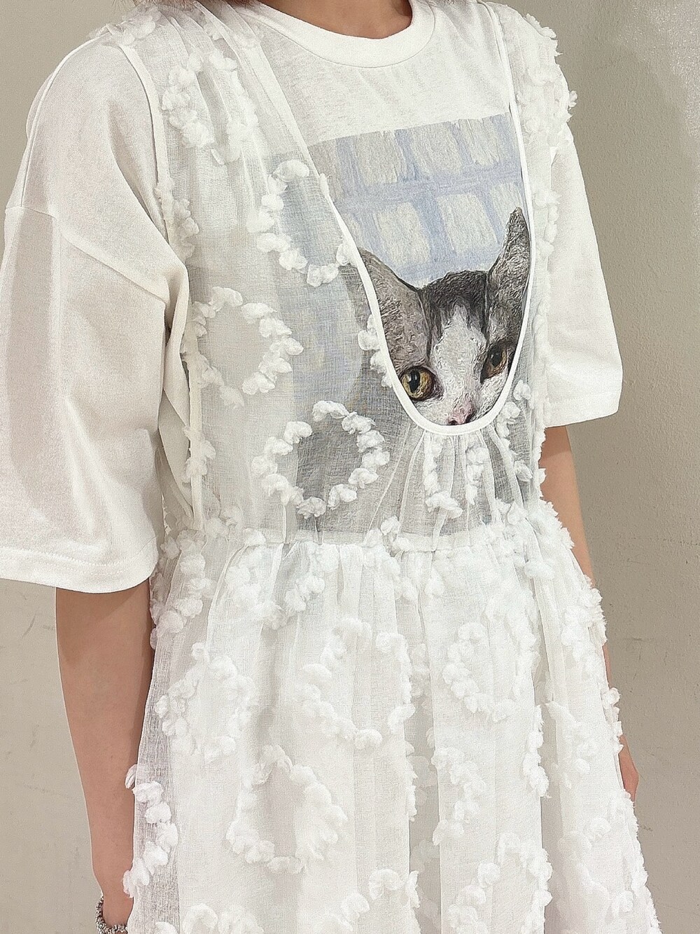 ピンク系のショルダーバッグ、ホワイト系のジャンパースカート、ホワイト系のTシャツ/カットソーを着用したレディースの夏コーディネートの6枚目の写真