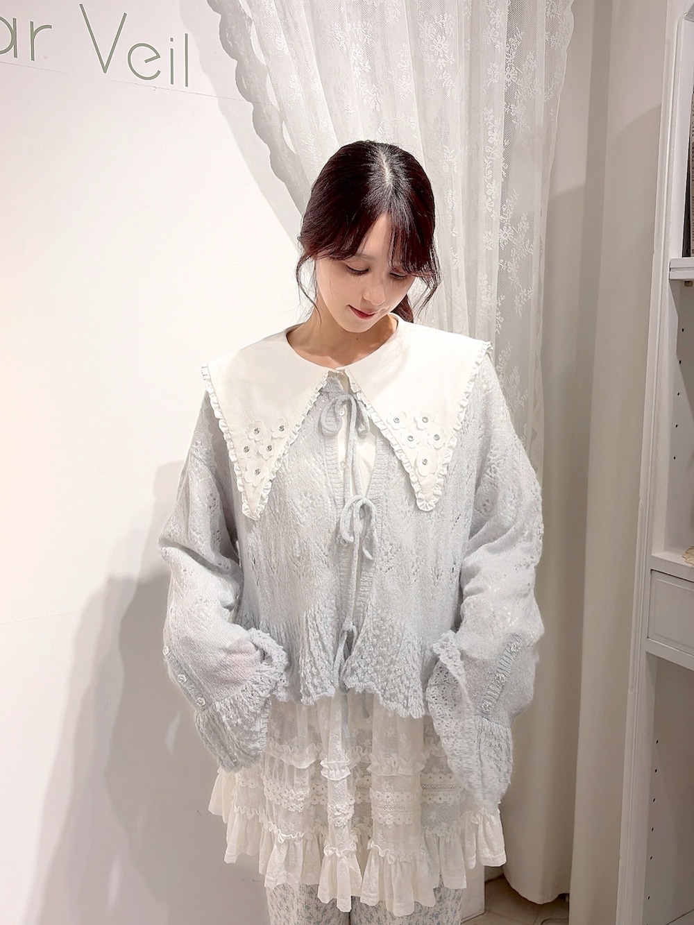 ブルー系のカーディガン/ボレロ、ホワイト系のシャツ/ブラウス、ホワイト系のハンドバッグを着用したレディースの夏コーディネートの4枚目の写真