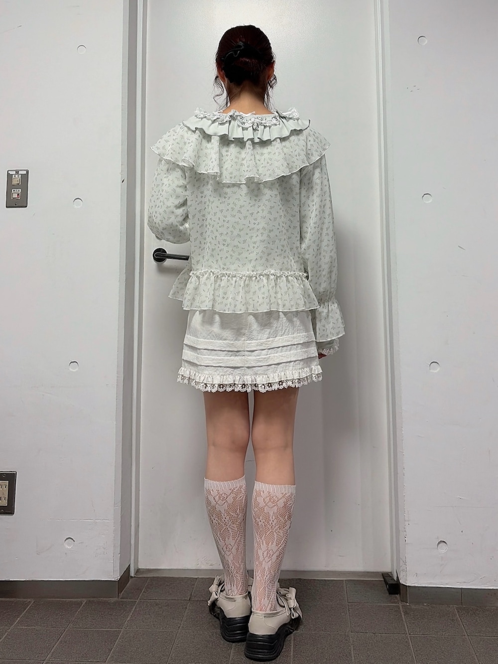 グリーン系のTシャツ/カットソー、ブルー系のカーディガン/ボレロ、ホワイト系のスカートを着用したレディースの冬コーディネートの2枚目の写真