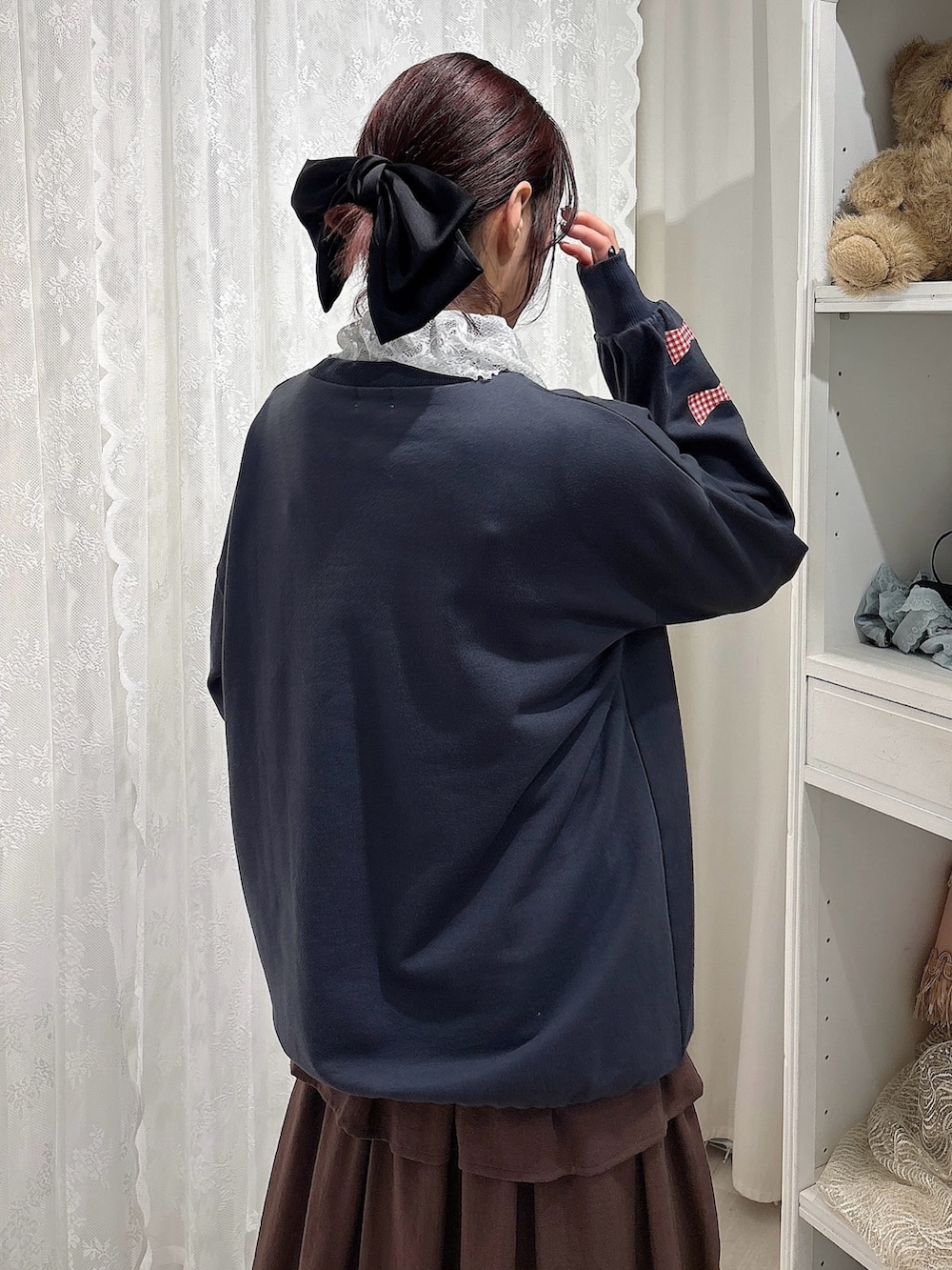 グレー系のスウェット、ブラウン系のトートバッグ、ブラウン系のスカートを着用したレディースの秋コーディネートの5枚目の写真