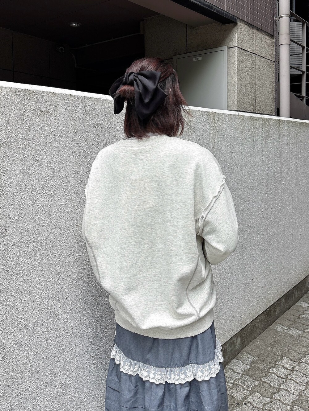 グレー系のスウェット、グレー系のスカート、グレー系のニット/セーターを着用したレディースの秋コーディネートの4枚目の写真