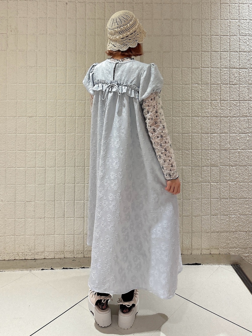 ブルー系のワンピース、ホワイト系のTシャツ/カットソー、ホワイト系のサンダルを着用したレディースの春コーディネートの2枚目の写真