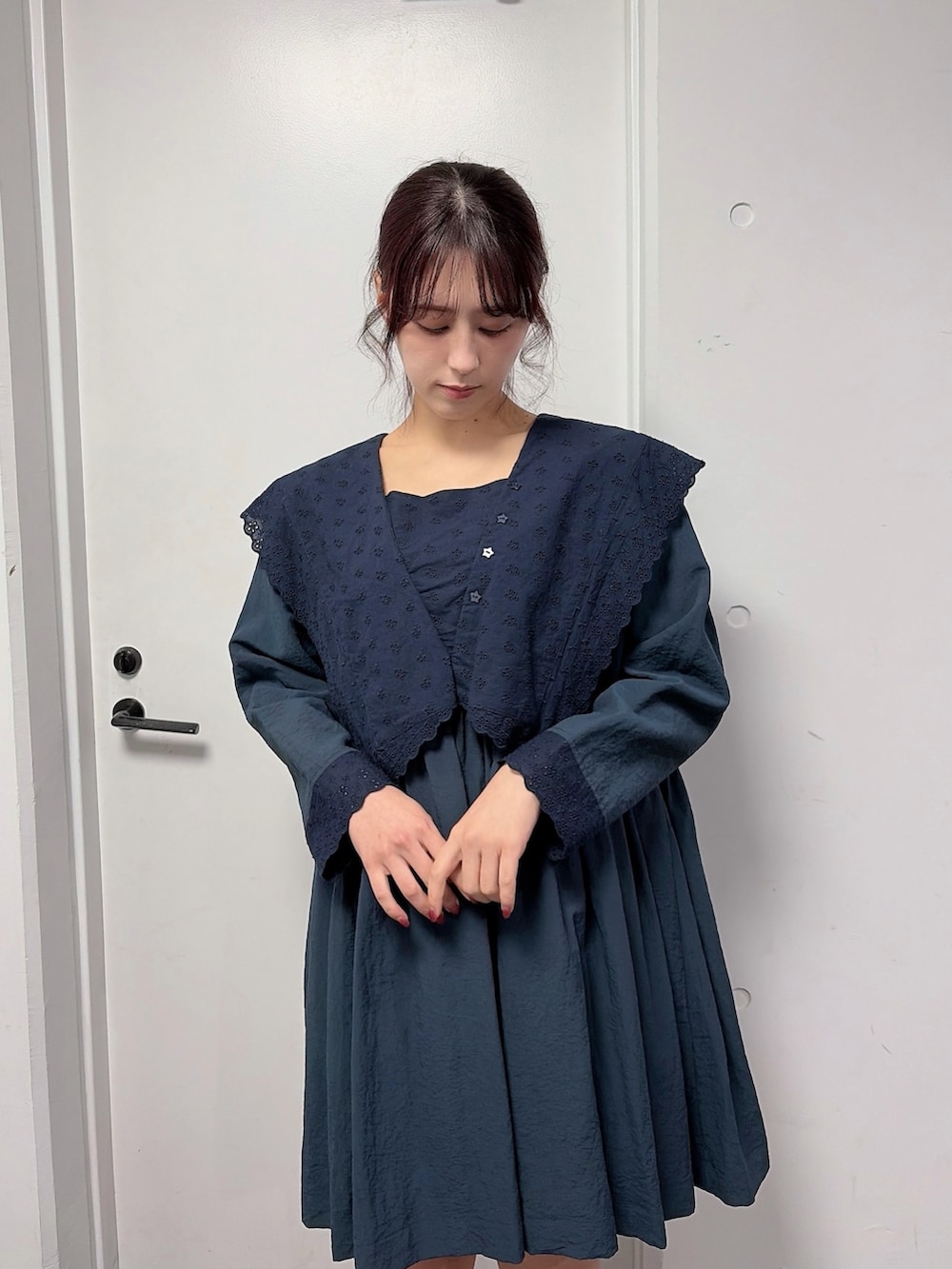 ブルー系のワンピース、ベージュ系のメッセンジャーバッグ、ブラック系のスニーカーを着用したレディースの冬コーディネートの3枚目の写真