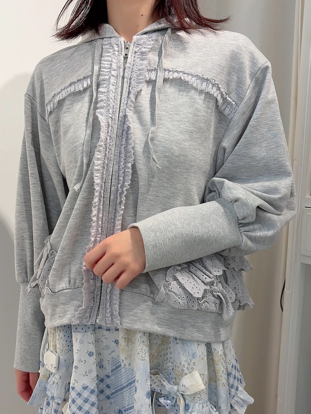 グレー系のパーカー、ブルー系のスカート、ホワイト系のバレエシューズを着用したレディースの冬コーディネートの5枚目の写真