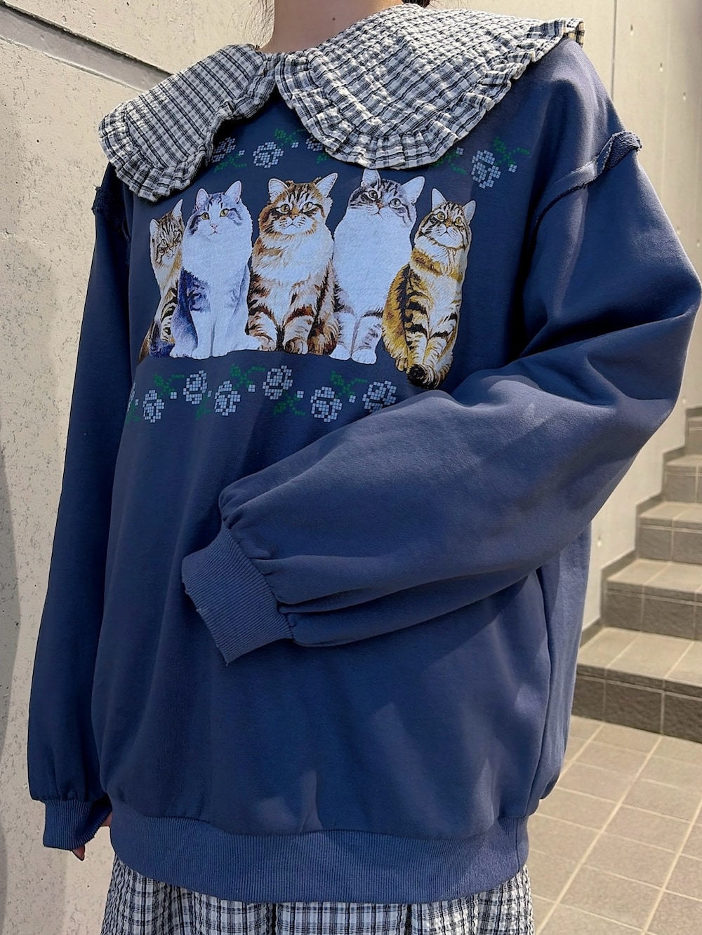 ブルー系のスウェット、ブルー系のワンピース、ブラック系のスニーカーを着用したレディースの冬コーディネートの5枚目の写真