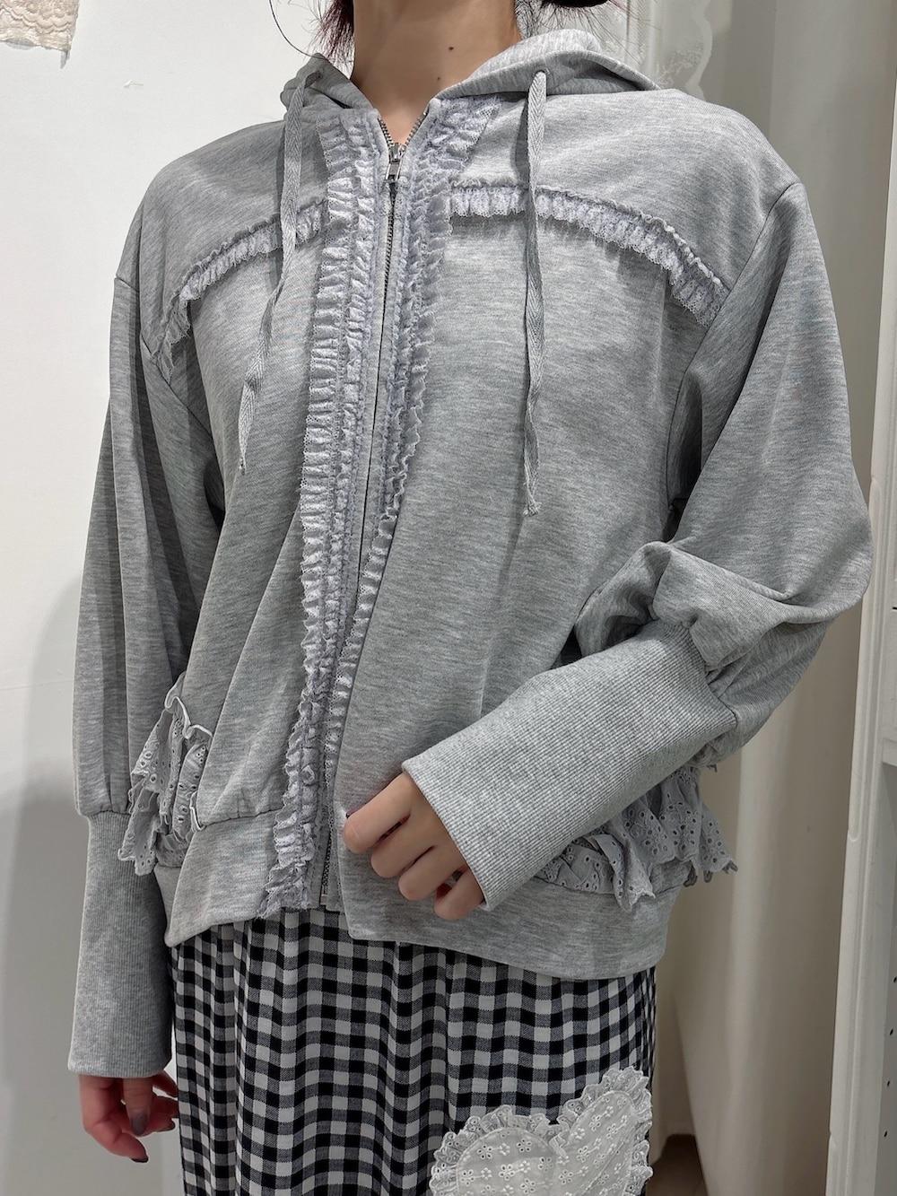 グレー系のパーカー、ブラック系のスカート、ホワイト系のスニーカーを着用したレディースの秋コーディネートの5枚目の写真