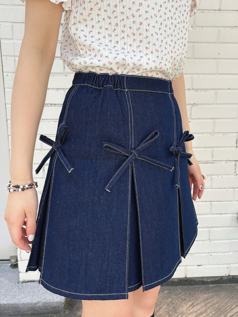 ブルー系のスカート、ブラック系のサンダル、ピンク系のTシャツ/カットソーを着用したレディースの春コーディネートの6枚目の写真