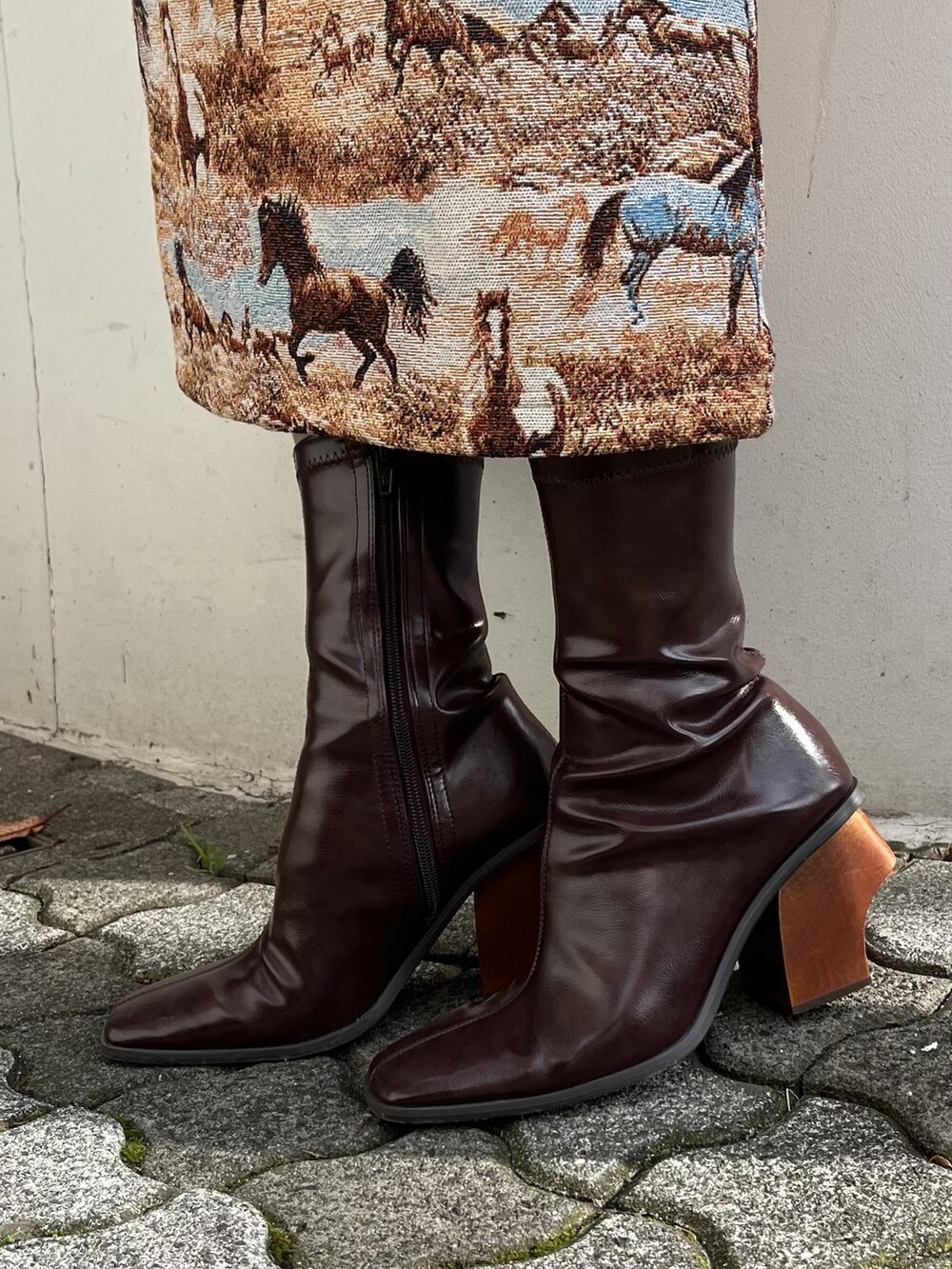 ブラック系のショルダーバッグ、ブラウン系のブーツ、ブラウン系のジャンパースカートを着用したレディースの冬コーディネートの3枚目の写真