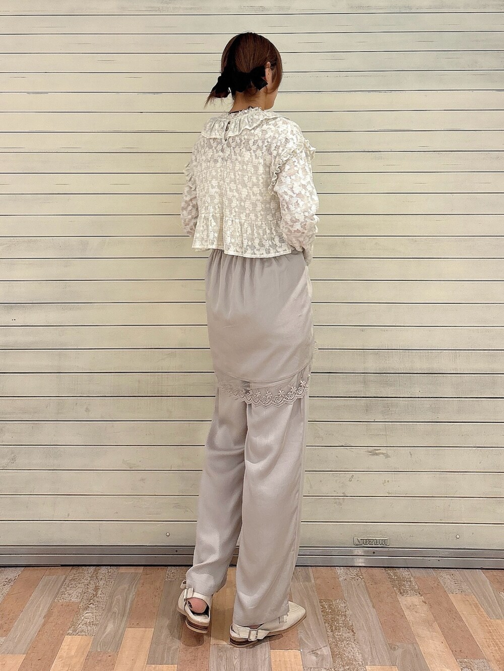 グレー系のスラックス、ホワイト系のローファー、ホワイト系のTシャツ/カットソーを着用したレディースの夏コーディネートの2枚目の写真