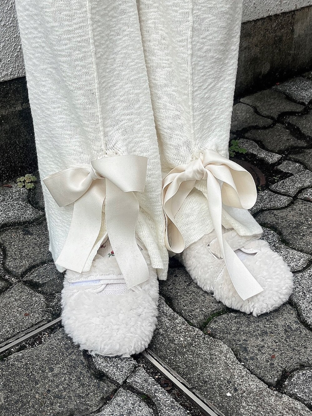 ピンク系のワンピース、ホワイト系のスウェットパンツ、ホワイト系のスリッポンを着用したレディースの秋コーディネートの4枚目の写真