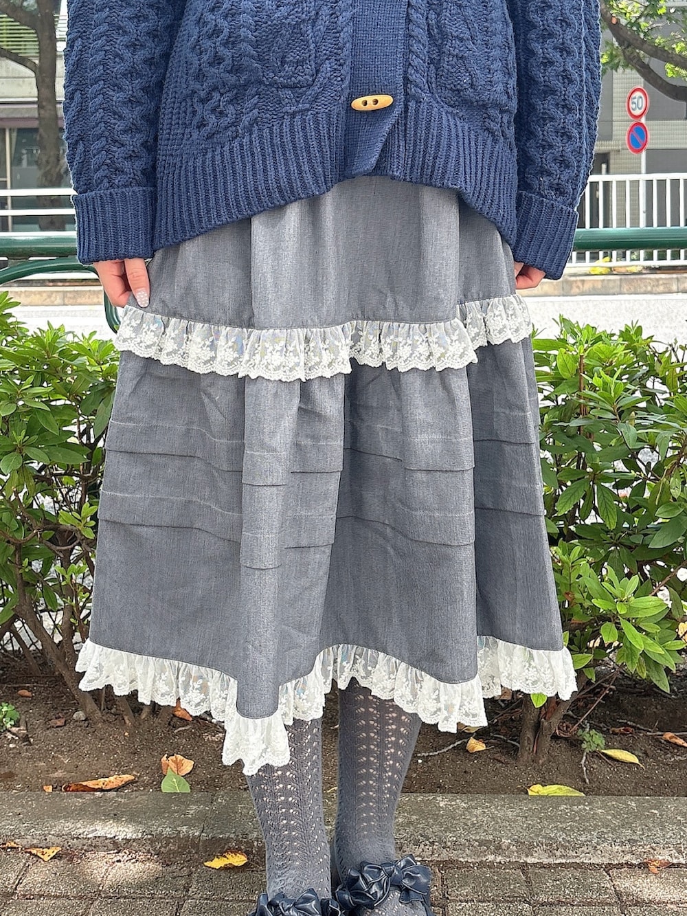 グレー系のスカート、ブルー系のカーディガン/ボレロ、ホワイト系のショルダーバッグを着用したレディースの夏コーディネートの7枚目の写真