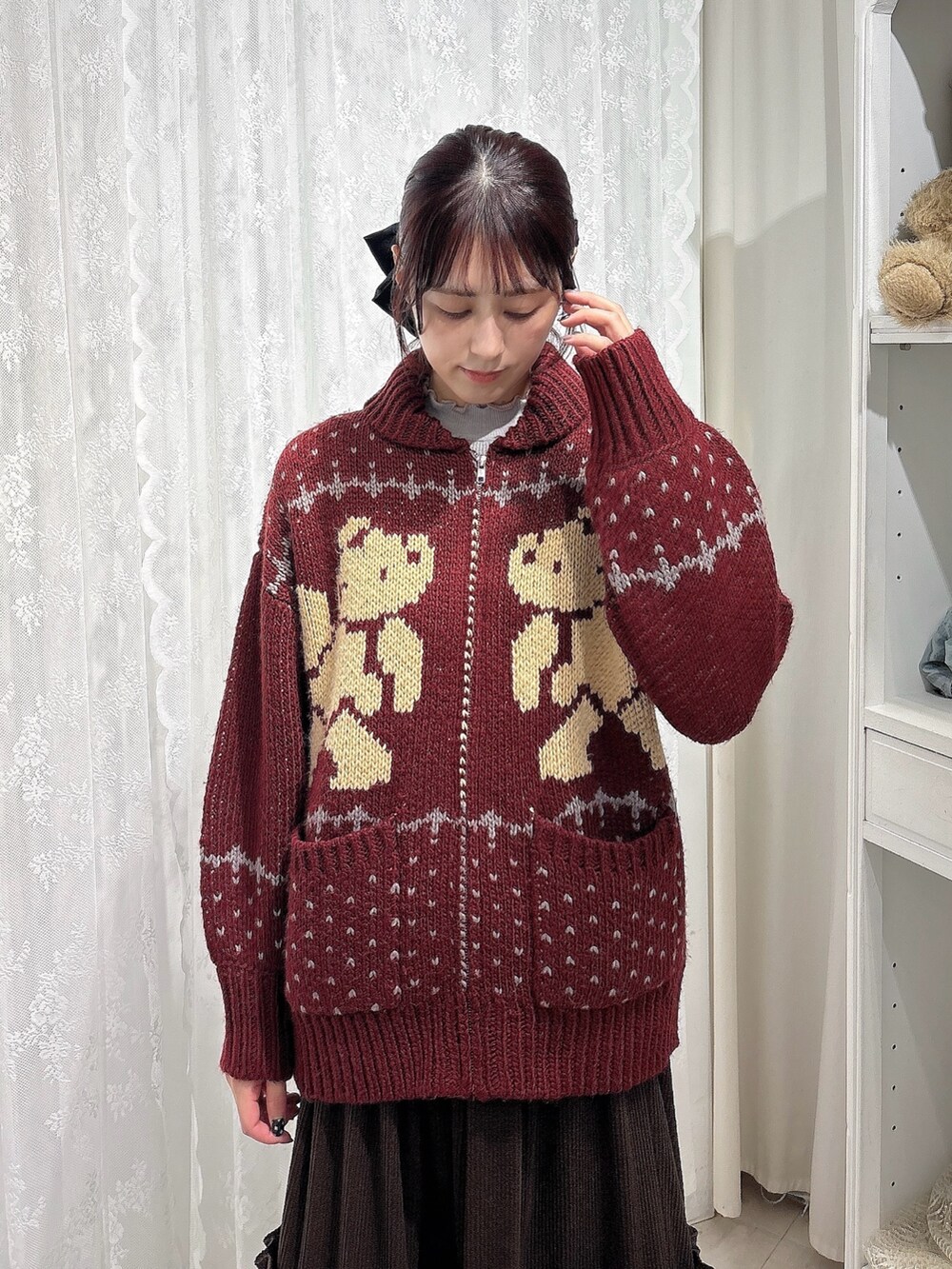 ブラウン系のスカート、ブラック系のショルダーバッグ、ホワイト系のスニーカーを着用したレディースの秋コーディネートの3枚目の写真