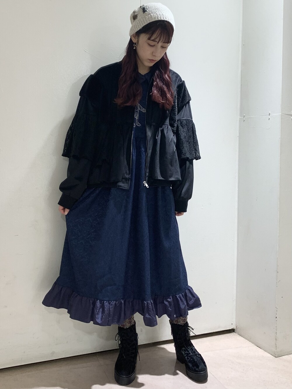 ブラック系のブルゾン、ブラック系のブーツ、ブルー系のワンピースを着用したレディースの冬コーディネートの2枚目の写真