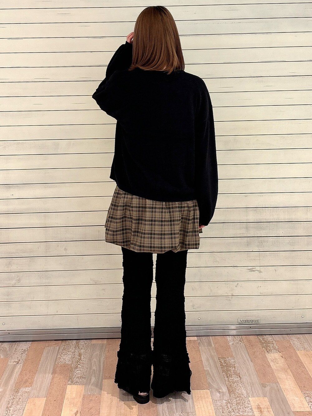 ブラック系のカーディガン/ボレロ、ブラウン系のスカート、ホワイト系のスラックスを着用したレディースの秋コーディネートの2枚目の写真