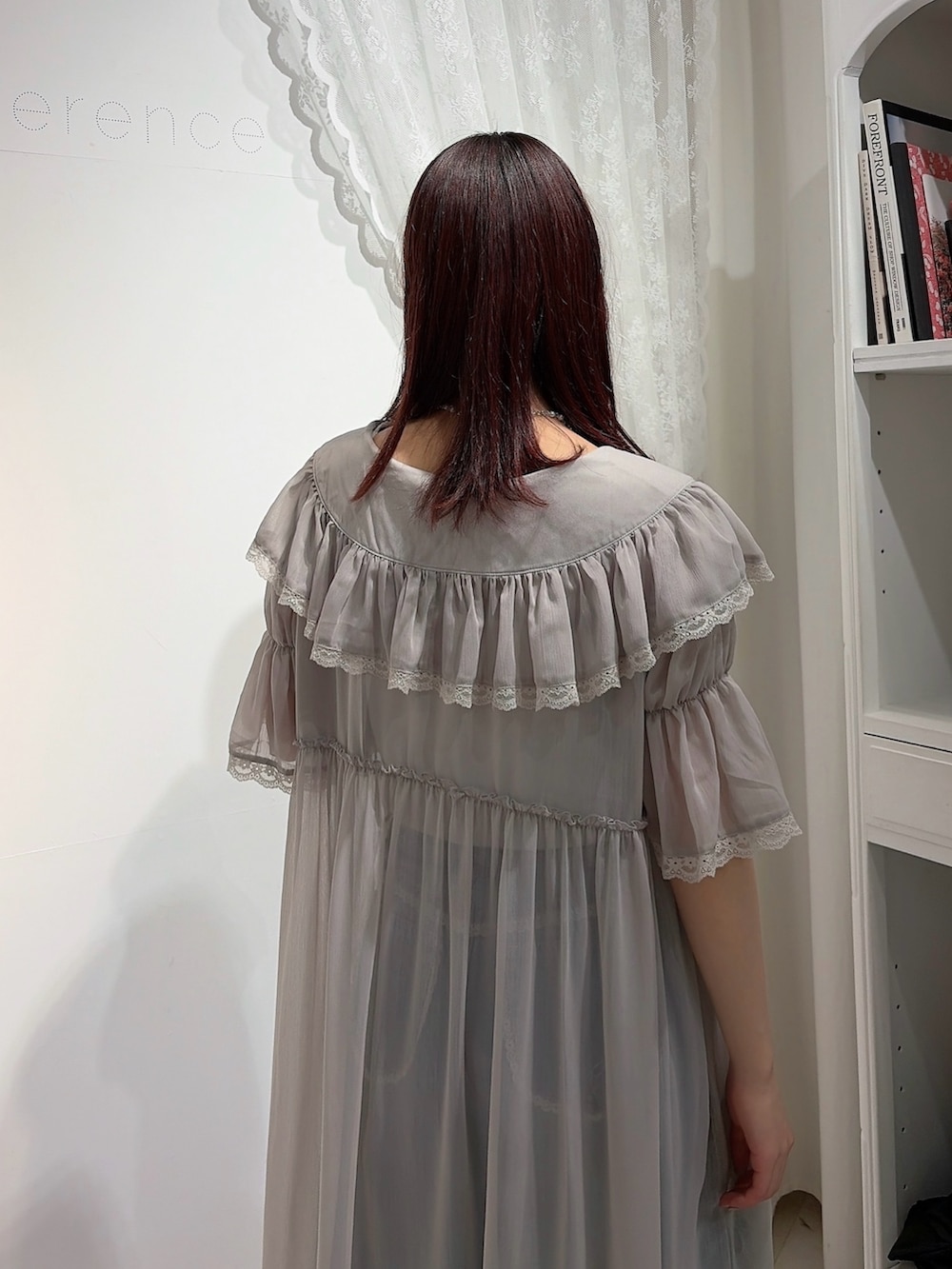 グレー系のワンピース、ホワイト系のキャミソール、ブルー系のデニムパンツを着用したレディースの春コーディネートの4枚目の写真