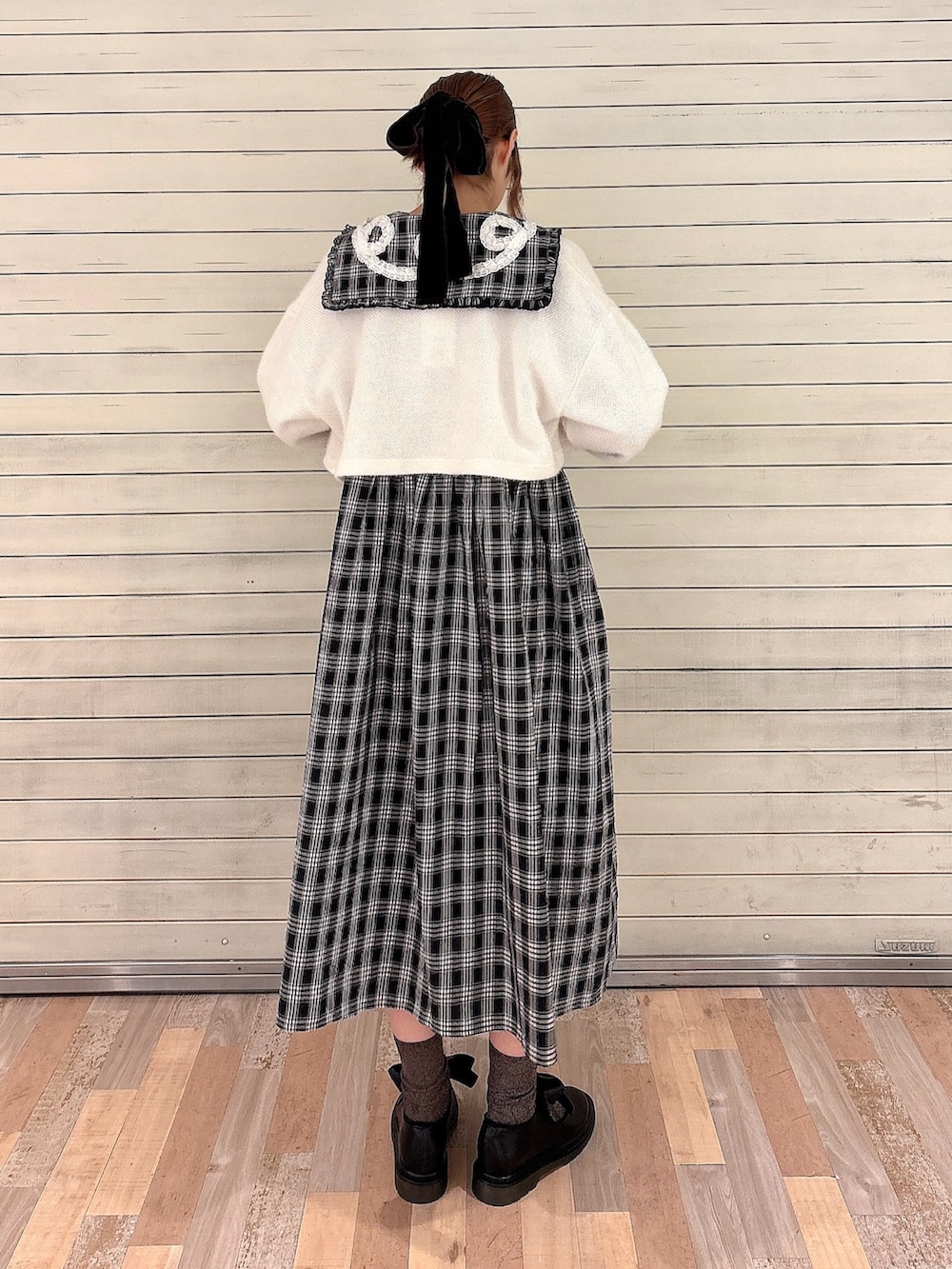 ブラック系のワンピース、ホワイト系のカーディガン/ボレロ、ブラック系のバレエシューズを着用したレディースの秋コーディネートの2枚目の写真