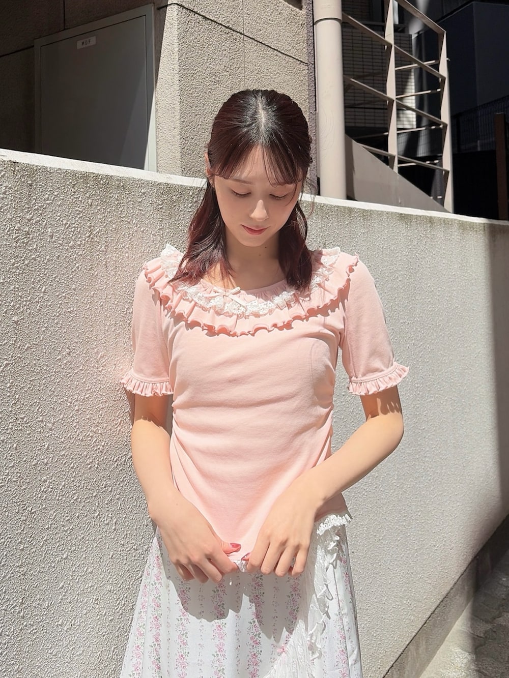 ピンク系のTシャツ/カットソー、ピンク系のスカート、ホワイト系のサンダルを着用したレディースの春コーディネートの3枚目の写真