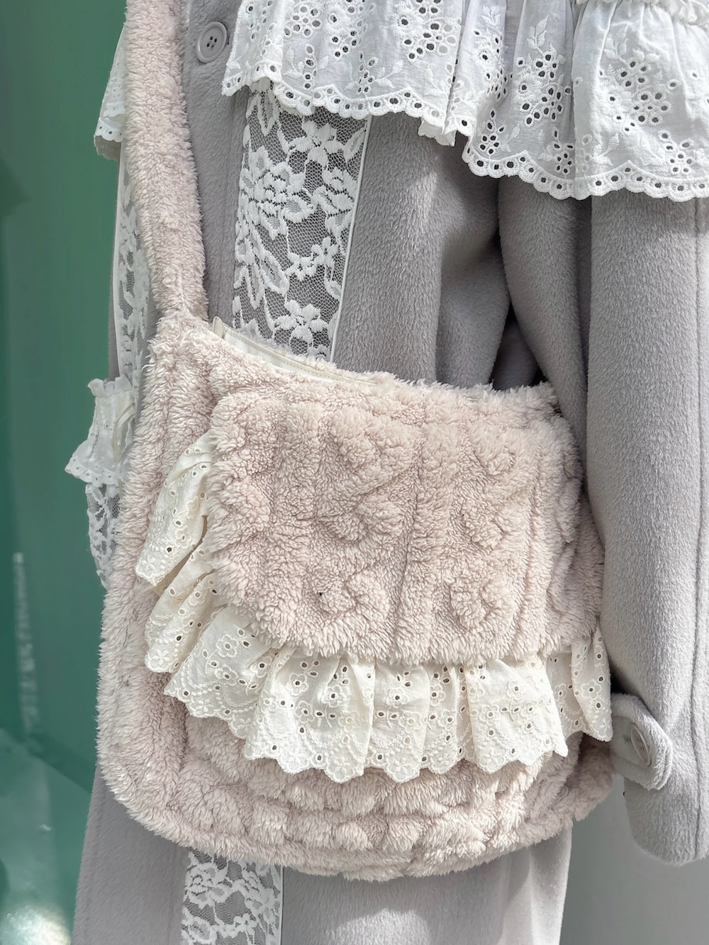 グレー系のチェスターコート、ベージュ系のショルダーバッグ、ホワイト系のワンピースを着用したレディースの秋コーディネートの6枚目の写真