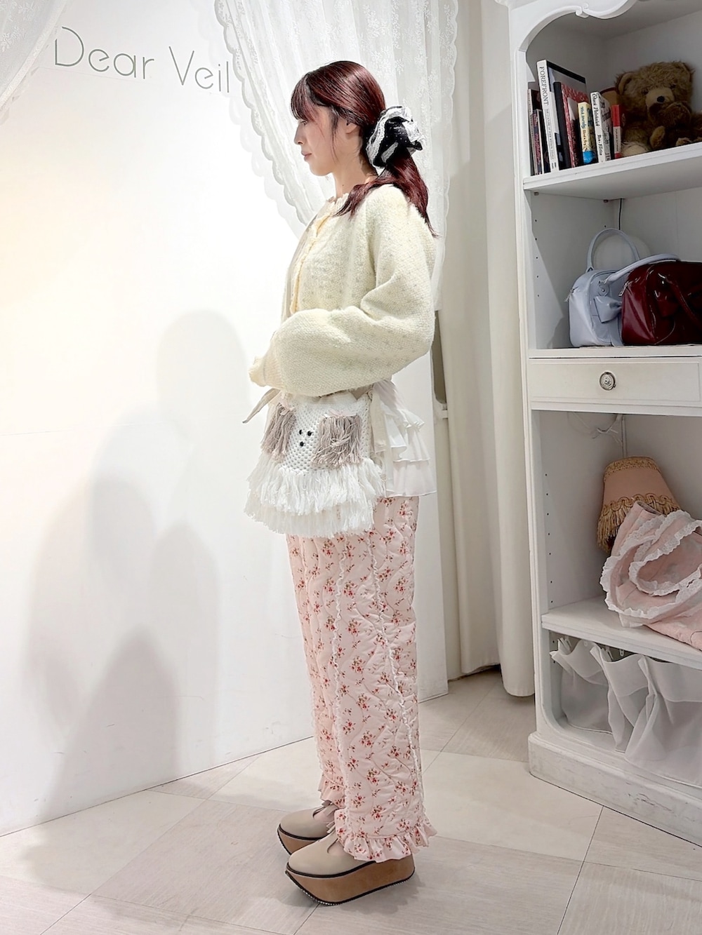 ホワイト系のカーディガン/ボレロ、ホワイト系のTシャツ/カットソー、ベージュ系のショルダーバッグを着用したレディースの秋コーディネートの2枚目の写真