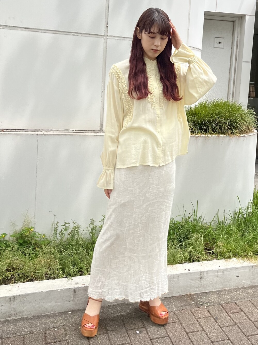 イエロー系のシャツ/ブラウス、ホワイト系のスカート、ベージュ系のトートバッグを着用したレディースの春コーディネートの2枚目の写真