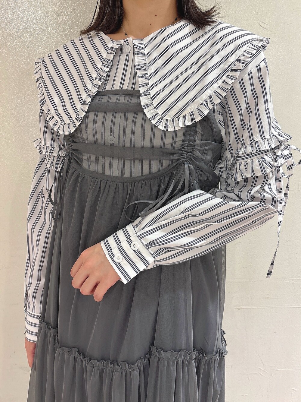 グレー系のワンピース、ホワイト系のシャツ/ブラウス、ブラック系のスニーカーを着用したレディースの夏コーディネートの5枚目の写真