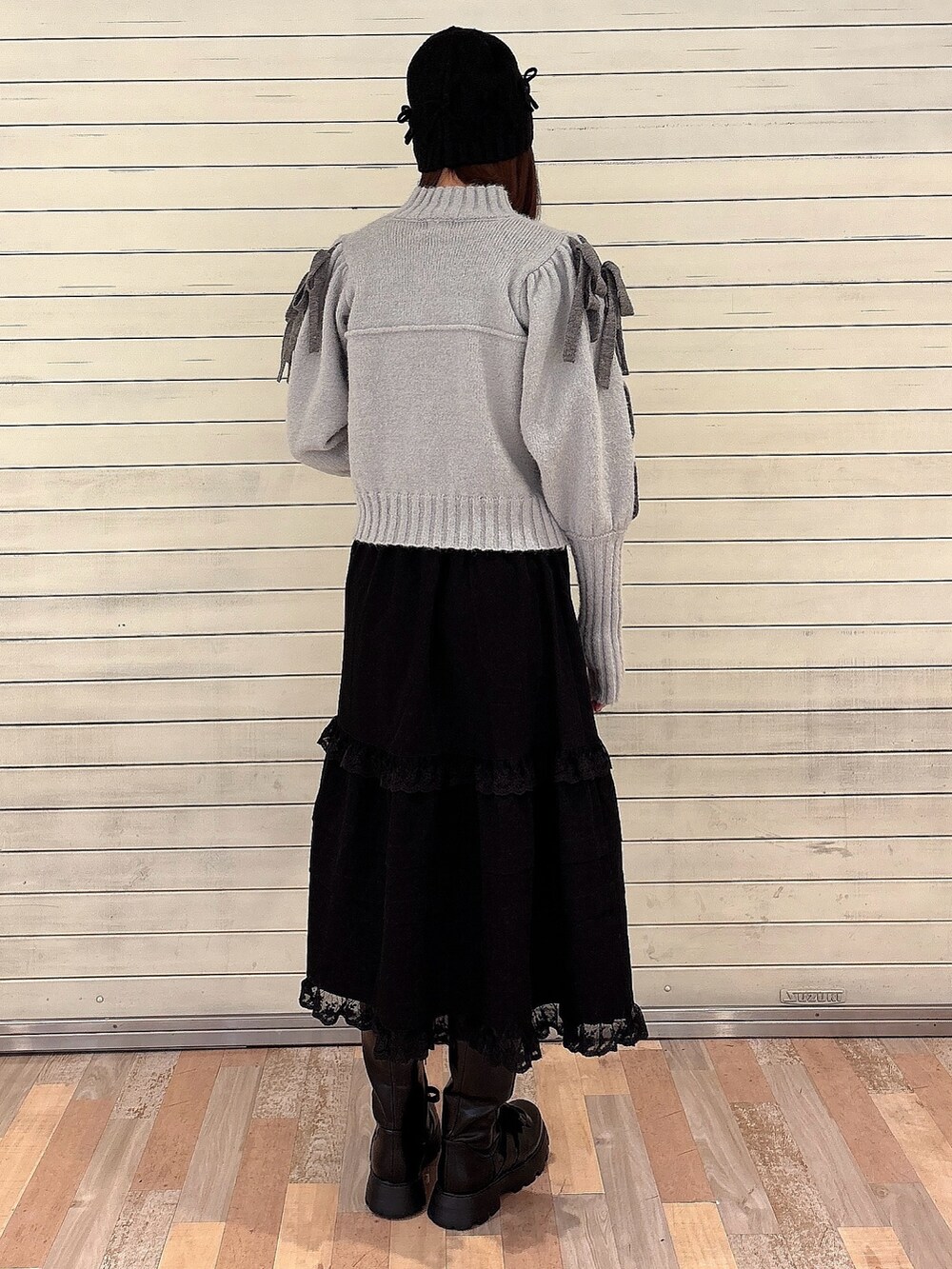 グレー系のカーディガン/ボレロ、ブラック系のスカート、ブラック系のブーツを着用したレディースの冬コーディネートの2枚目の写真