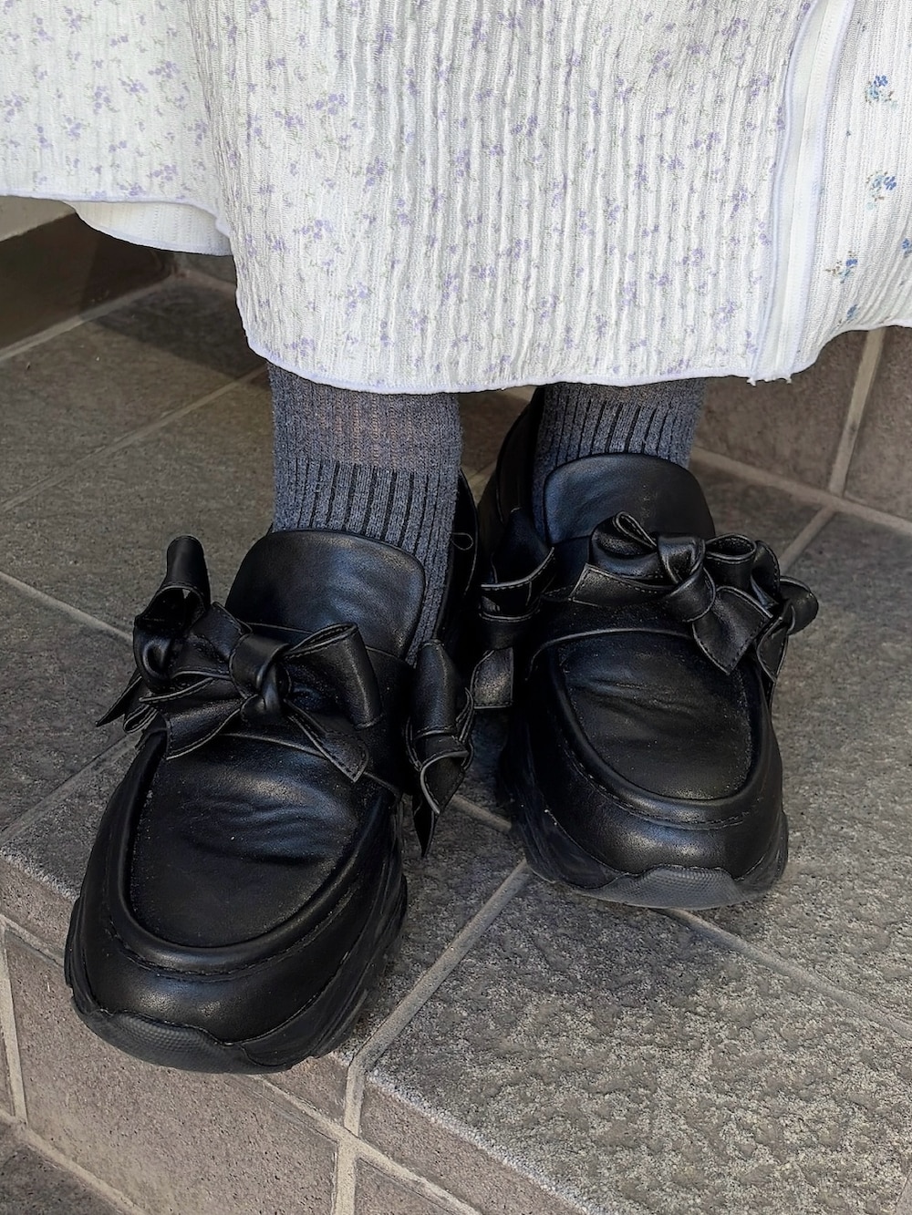 グレー系のテーラードジャケット、グレー系のTシャツ/カットソー、パープル系のスカートを着用したレディースの冬コーディネートの7枚目の写真