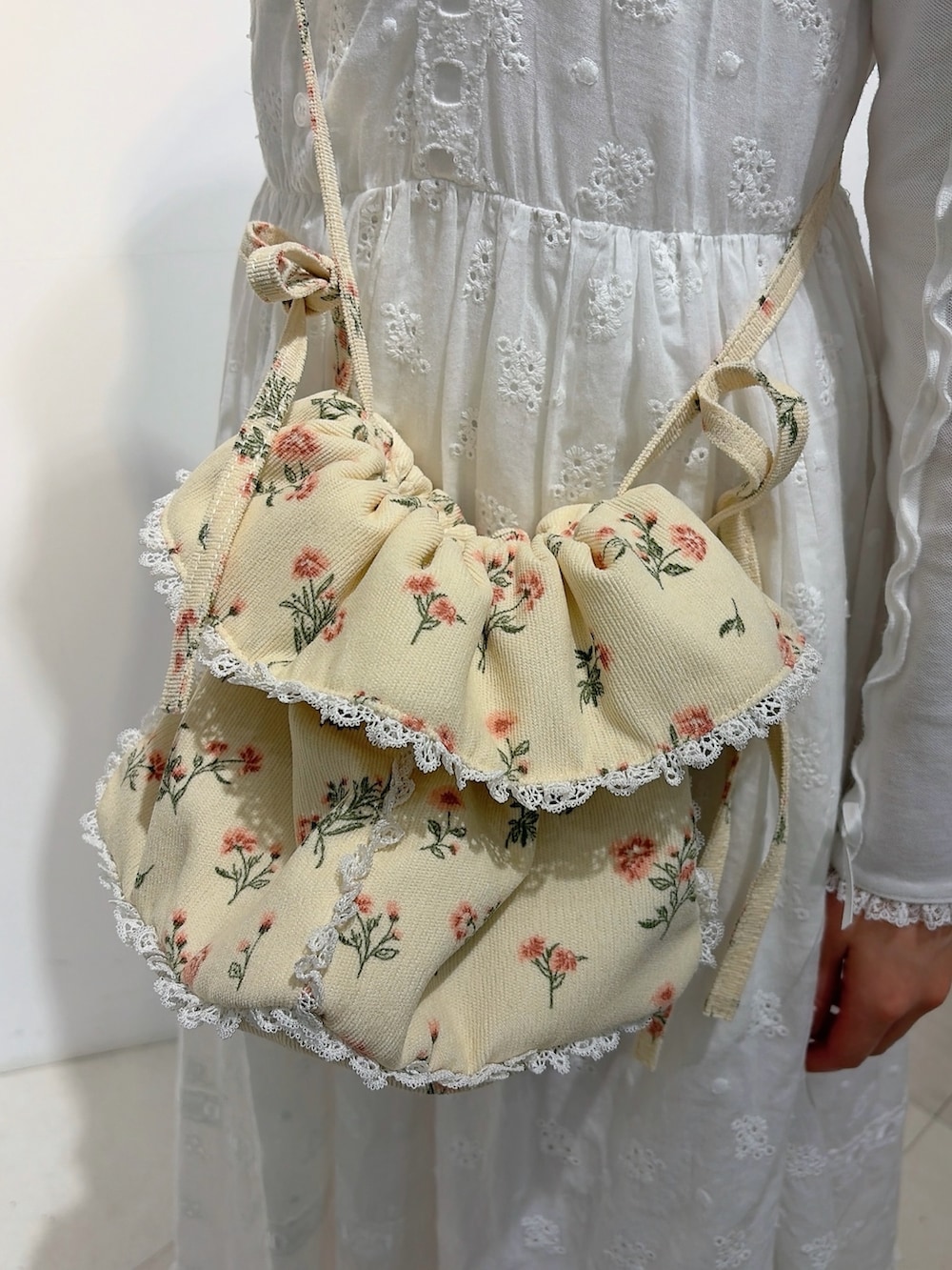 ホワイト系のポロシャツ、ホワイト系のワンピース、ホワイト系のショルダーバッグを着用したレディースの冬コーディネートの5枚目の写真