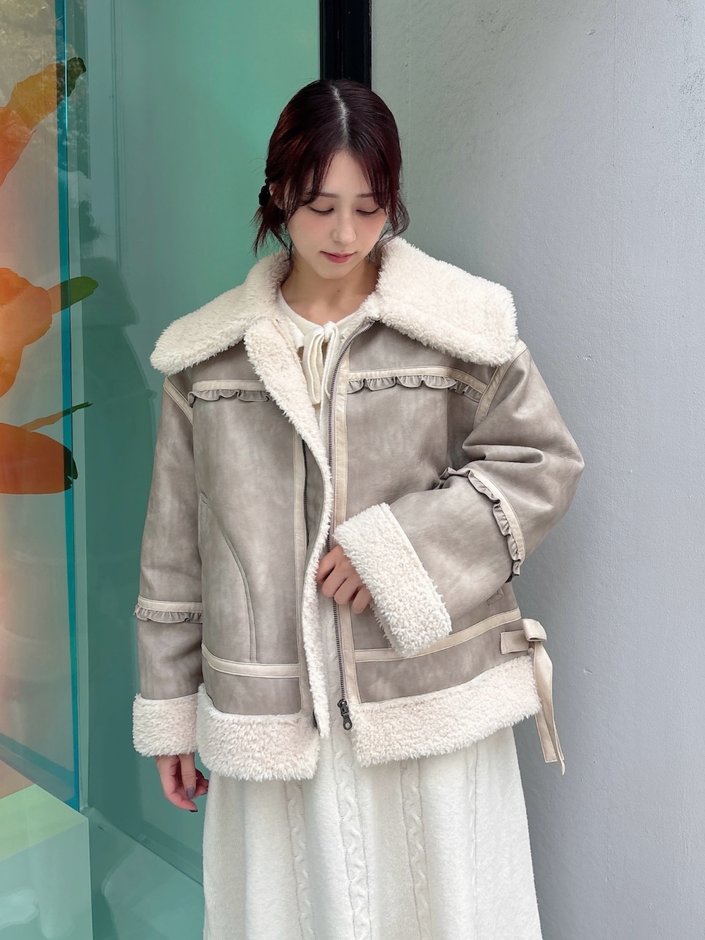 ベージュ系のムートンコート、ホワイト系のワンピース、ブラック系のブーツを着用したレディースの秋コーディネートの3枚目の写真