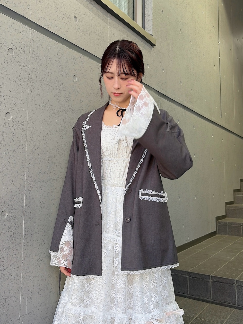 グレー系のテーラードジャケット、ホワイト系のワンピース、ホワイト系のスカートを着用したレディースの冬コーディネートの3枚目の写真