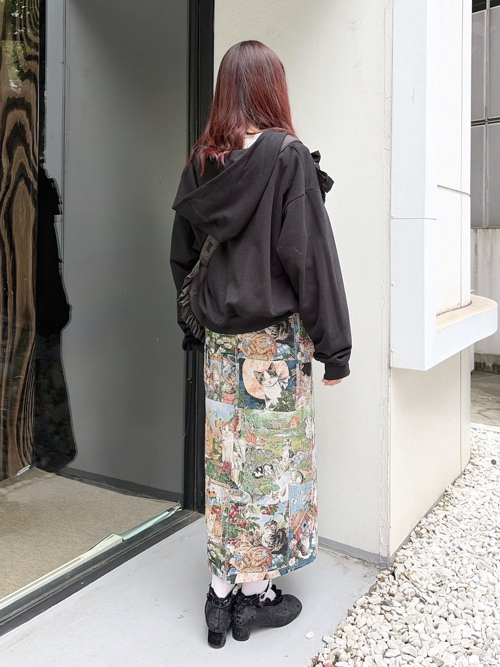 グリーン系のジャンパースカート、ブラック系のパンプス、ホワイト系のTシャツ/カットソーを着用したレディースの夏コーディネートの3枚目の写真