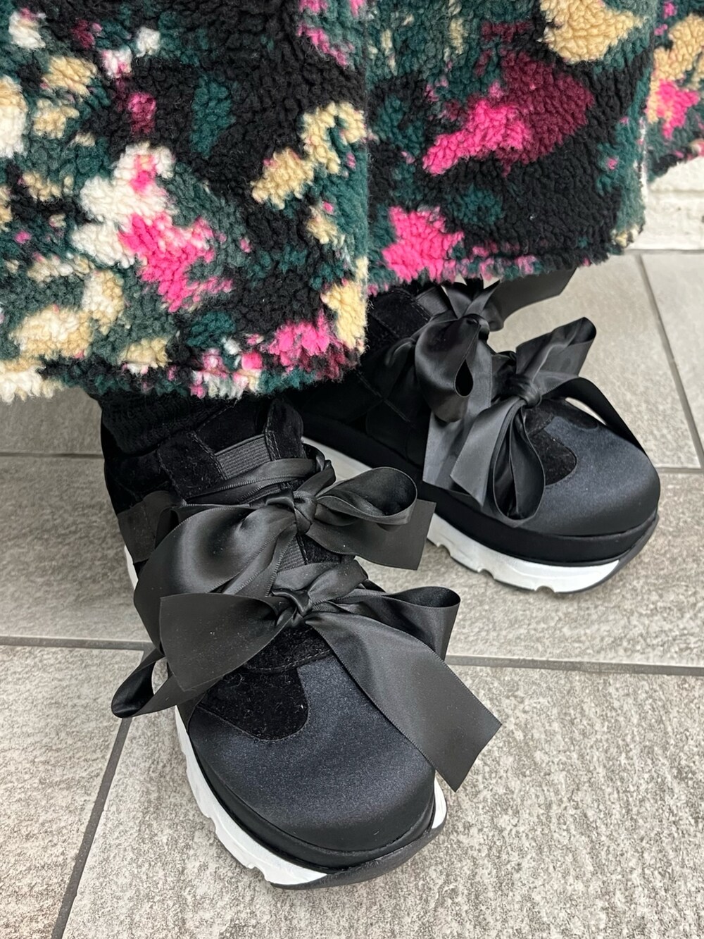 ブラック系のシャツ/ブラウス、ブラック系のスニーカー、ブラック系のベストを着用したレディースの冬コーディネートの3枚目の写真