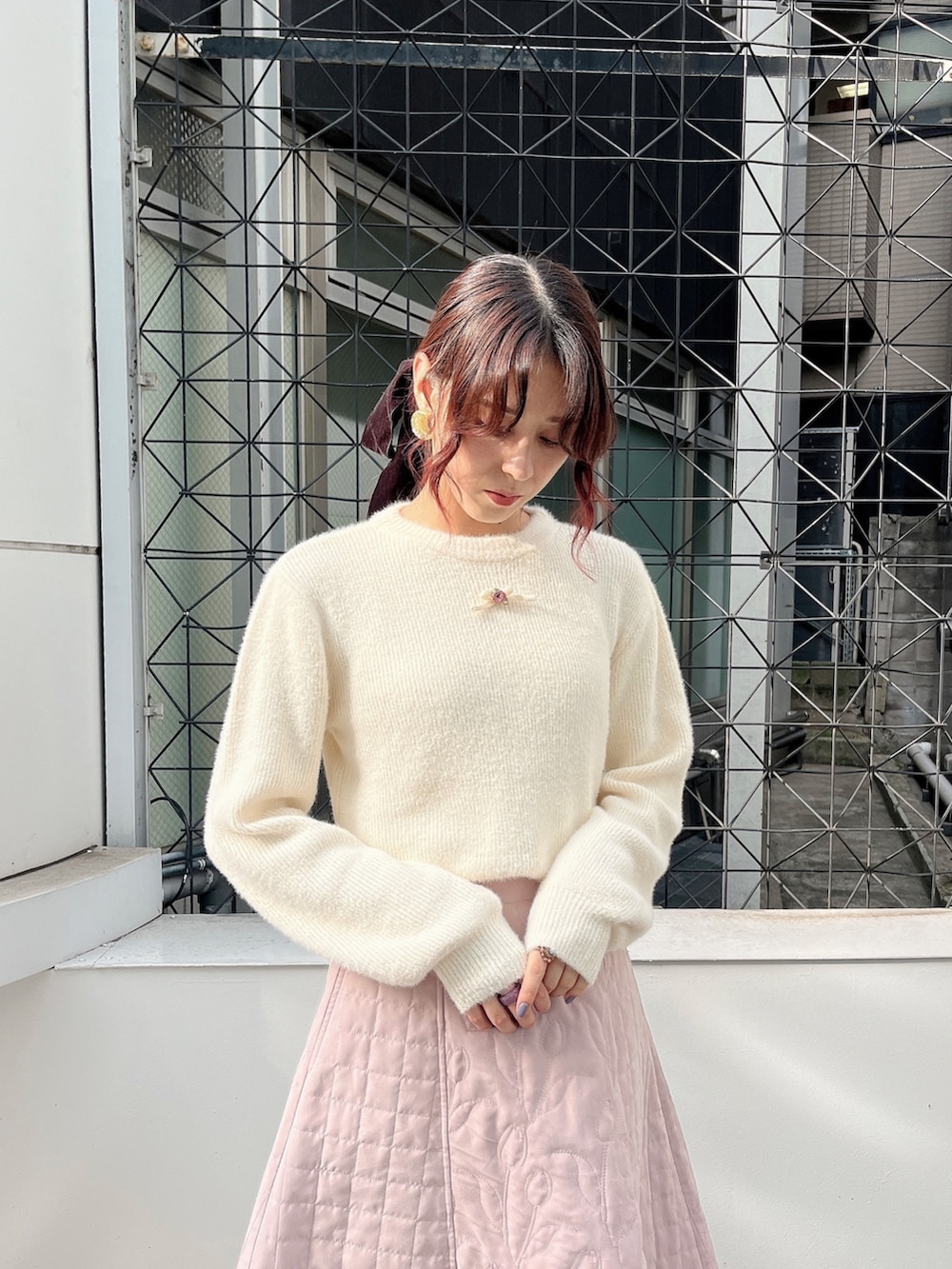 ピンク系のスカート、ピンク系のブルゾン、ホワイト系のニット/セーターを着用したレディースの夏コーディネートの3枚目の写真