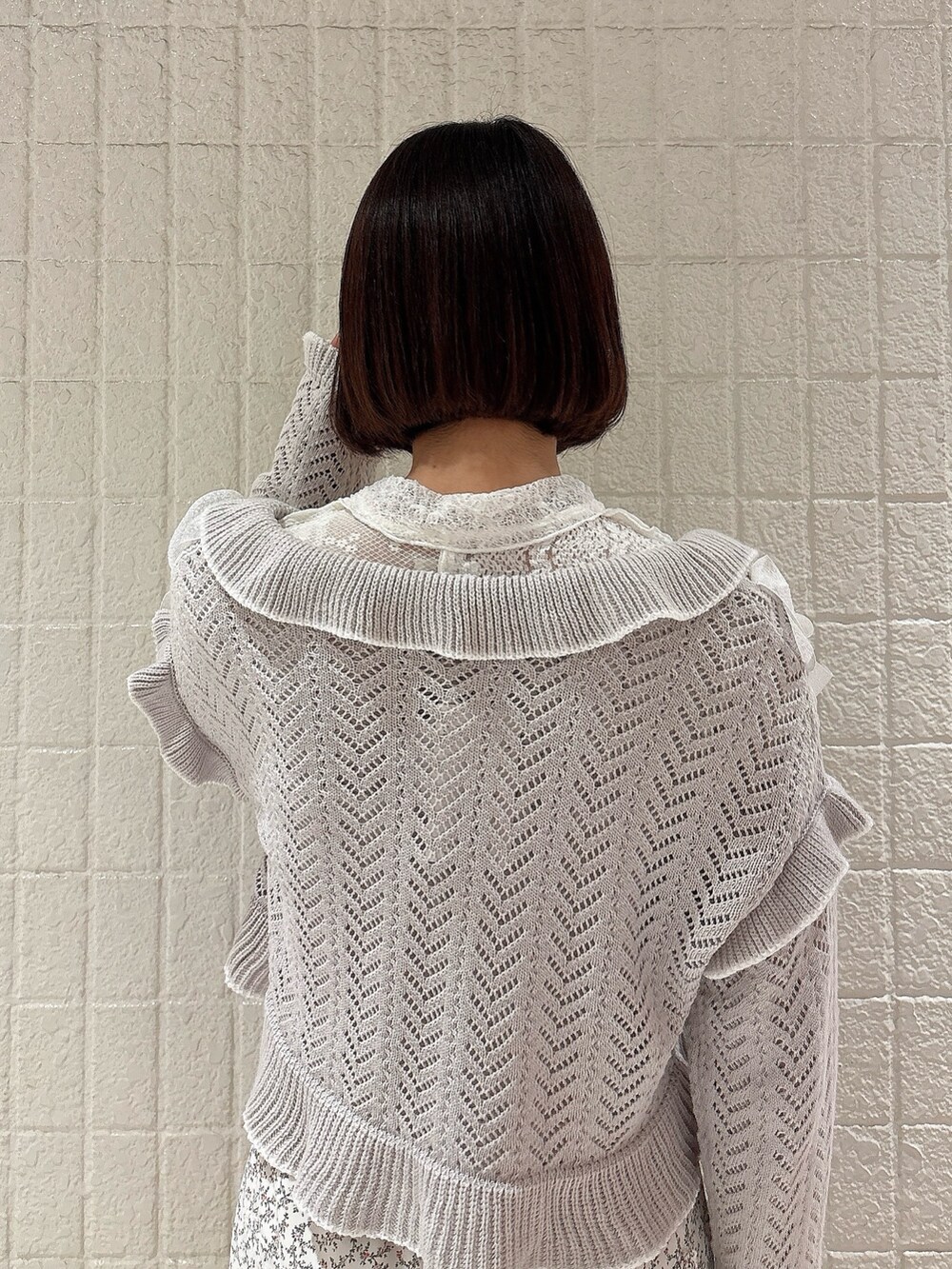 ホワイト系のカーディガン/ボレロ、グレー系のカーディガン/ボレロ、ホワイト系のスカートを着用したレディースの冬コーディネートの4枚目の写真