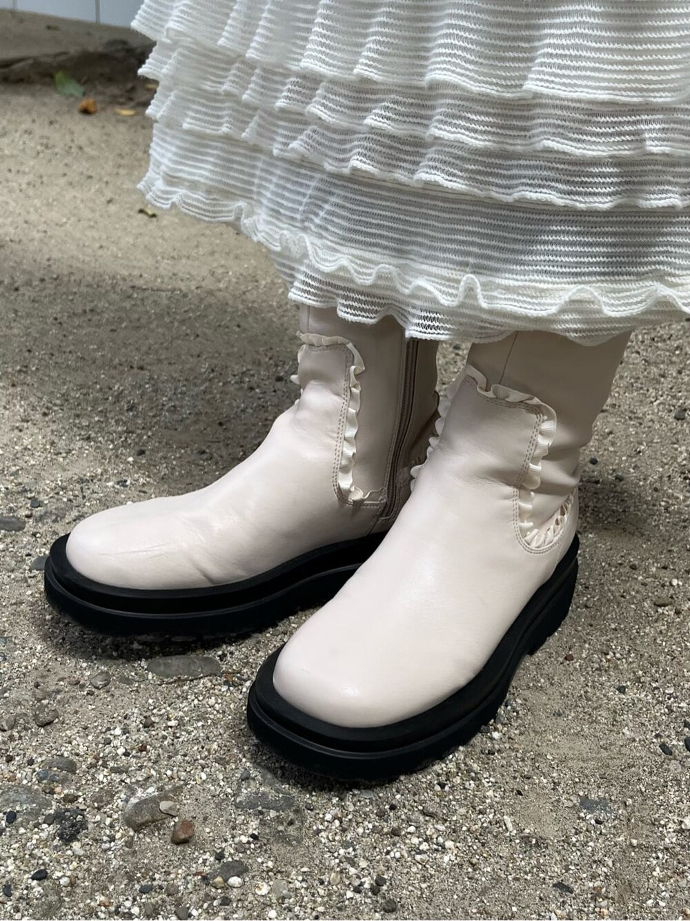 ピンク系のニット/セーター、ホワイト系のブーツ、ホワイト系のワンピースを着用したレディースの夏コーディネートの3枚目の写真