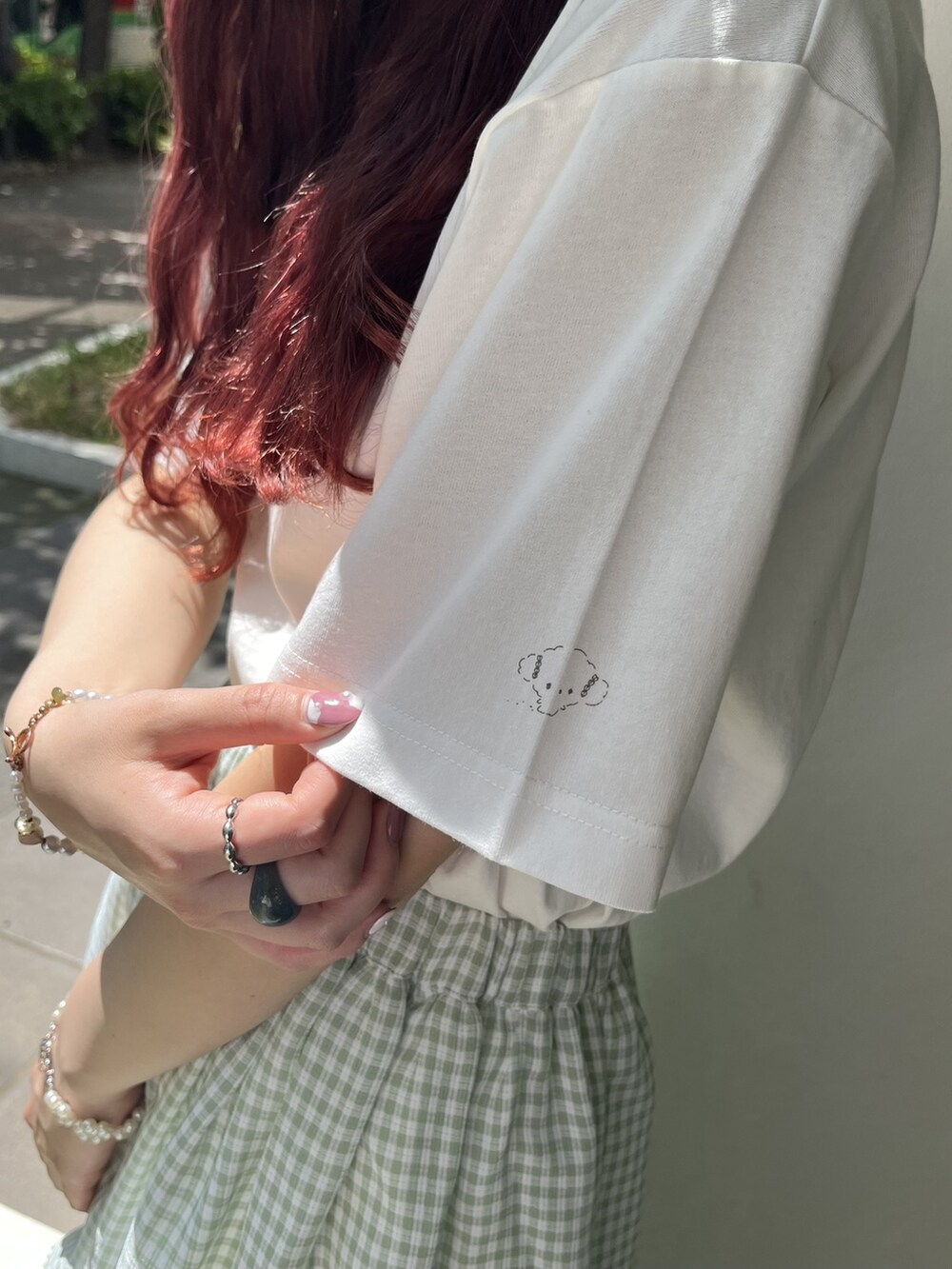 グリーン系のスカート、ホワイト系のスニーカー、ホワイト系のTシャツ/カットソーを着用したレディースの夏コーディネートの4枚目の写真