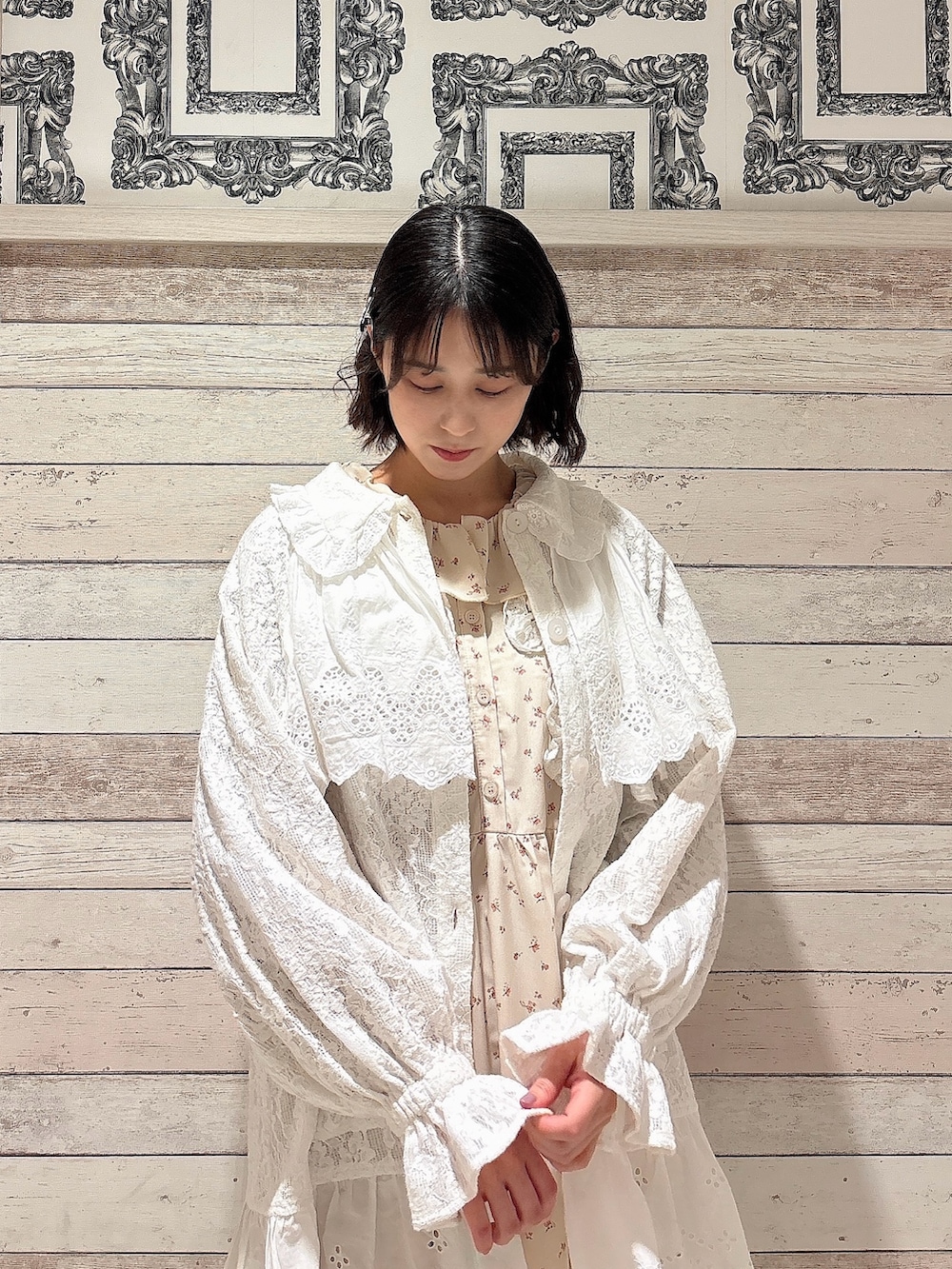 ホワイト系のテーラードジャケット、ホワイト系のワンピース、ホワイト系のスニーカーを着用したレディースの冬コーディネートの3枚目の写真