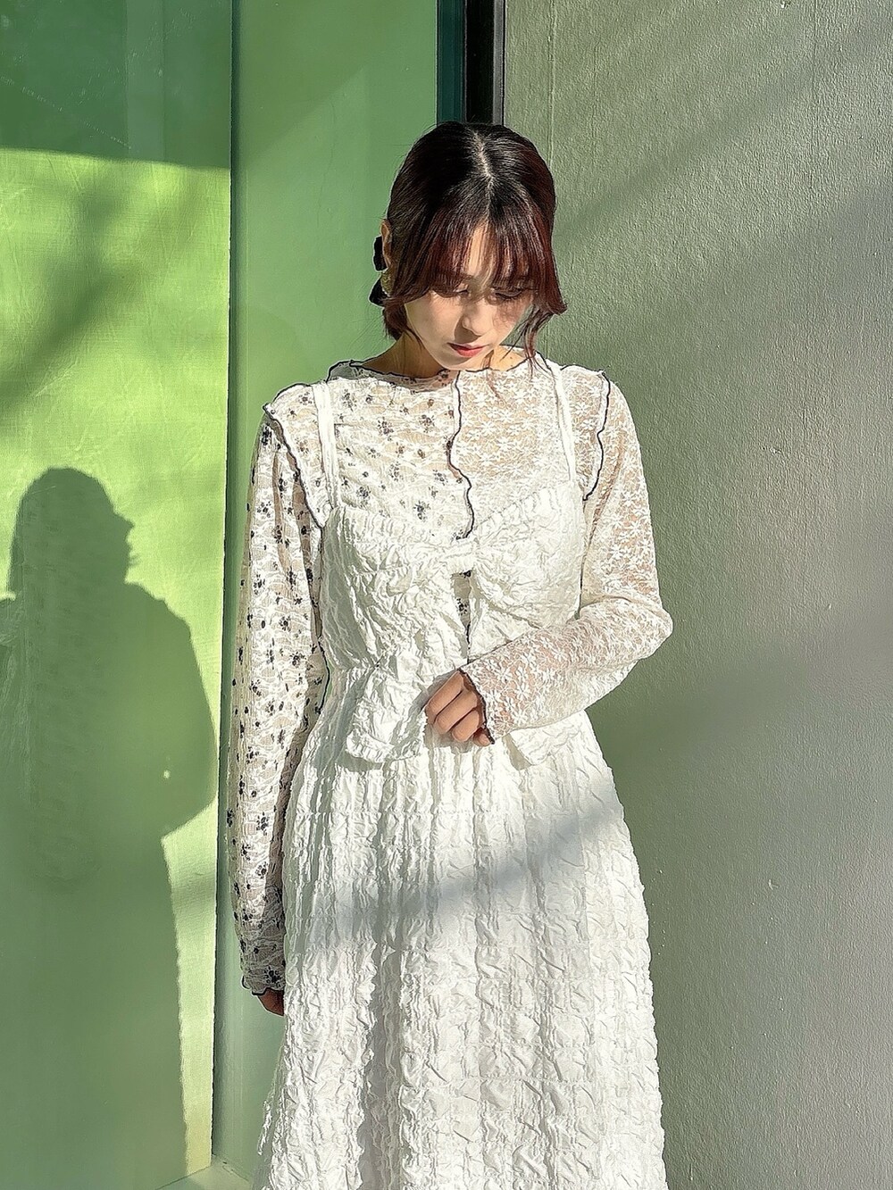 ホワイト系のワンピース、ホワイト系のTシャツ/カットソー、ピンク系のパンプスを着用したレディースの冬コーディネートの2枚目の写真