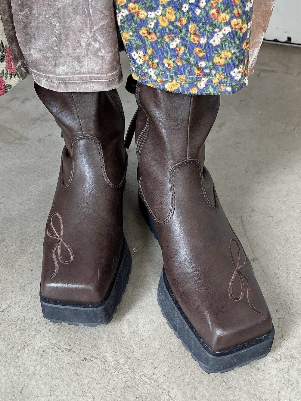 グレー系のニット/セーター、ピンク系のワンピース、ブラウン系のブーツを着用したレディースの夏コーディネートの6枚目の写真