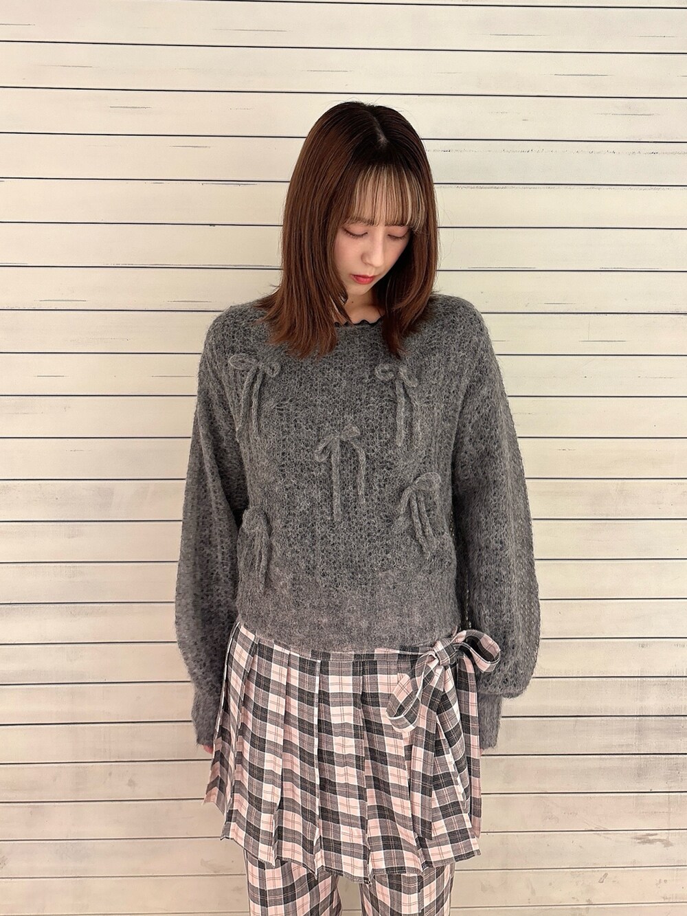 グレー系のニット/セーター、ブラック系のTシャツ/カットソー、ピンク系のスラックスを着用したレディースの秋コーディネートの3枚目の写真