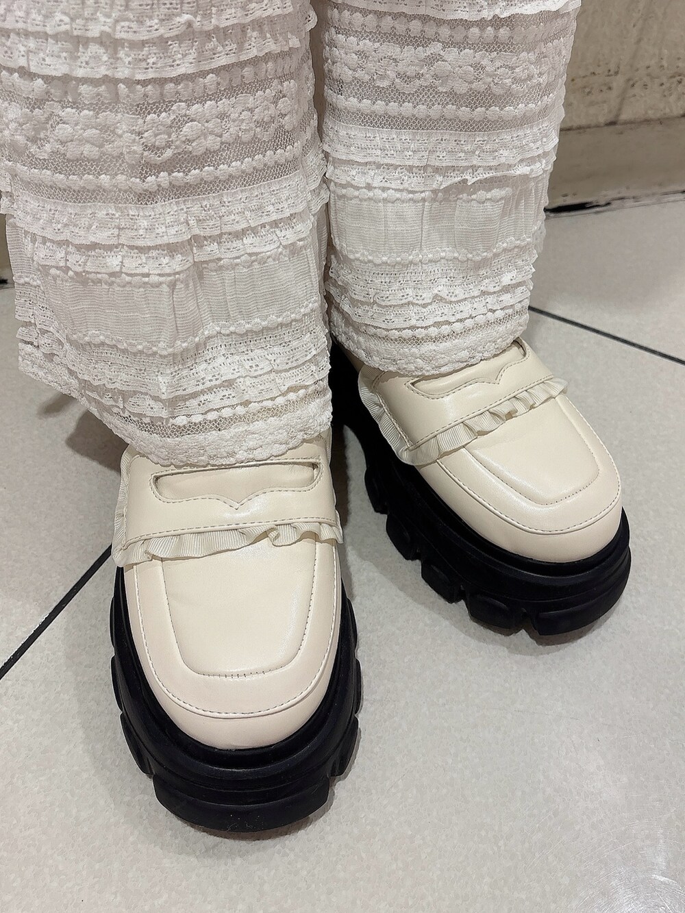 ホワイト系のワンピース、ホワイト系のその他パンツ、ホワイト系のローファーを着用したレディースの冬コーディネートの6枚目の写真