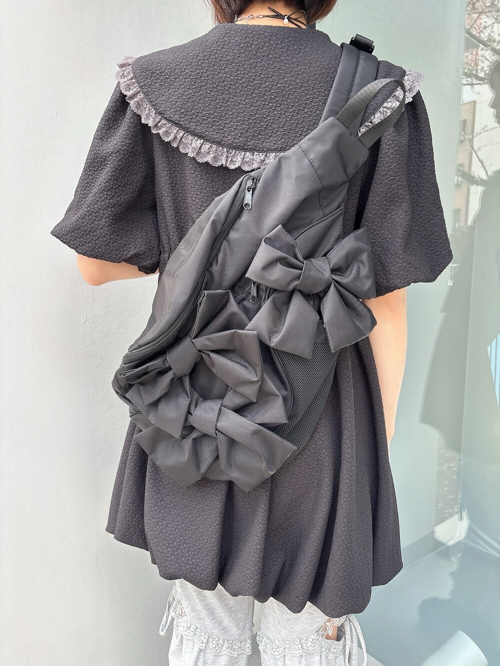 グレー系のスウェットパンツ、ブラック系のスニーカー、ブラック系のワンピースを着用したレディースの春コーディネートの6枚目の写真